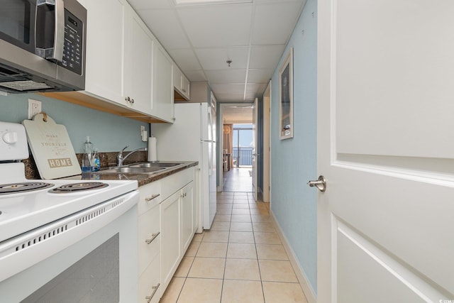 kitchen featuring white cabinetry, light tile patterned floors, a drop ceiling, and white range with electric cooktop