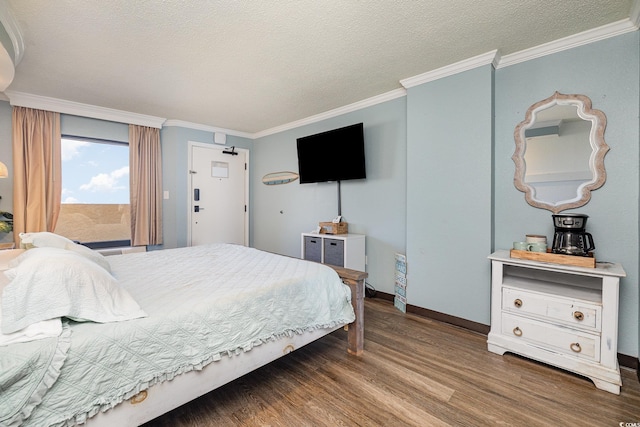 bedroom featuring wood-type flooring, ornamental molding, and a textured ceiling