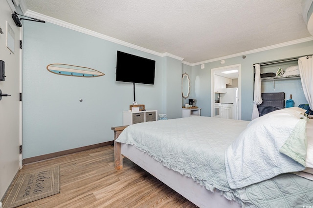 bedroom with connected bathroom, ornamental molding, a textured ceiling, light wood-type flooring, and white fridge