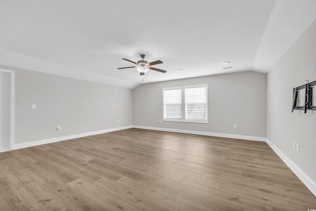 spare room featuring lofted ceiling, light hardwood / wood-style flooring, and ceiling fan