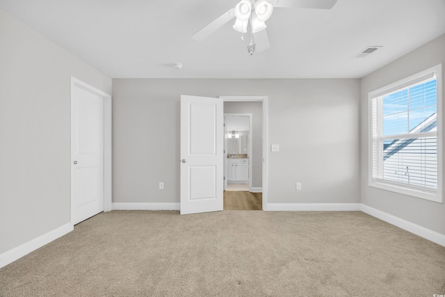 unfurnished bedroom with light carpet and ceiling fan