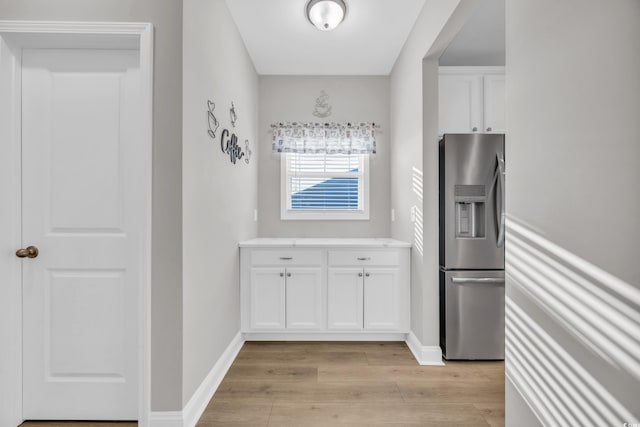 kitchen with white cabinetry, light hardwood / wood-style floors, and stainless steel refrigerator with ice dispenser