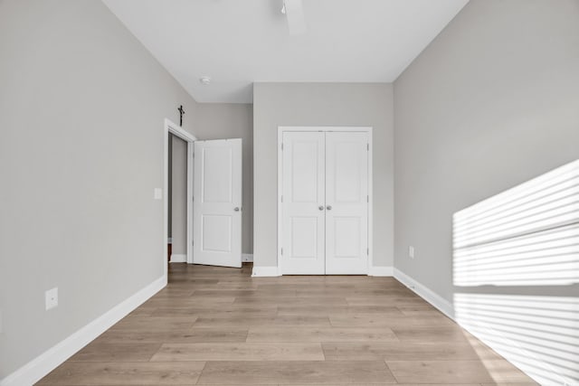 unfurnished bedroom with light hardwood / wood-style flooring and a closet