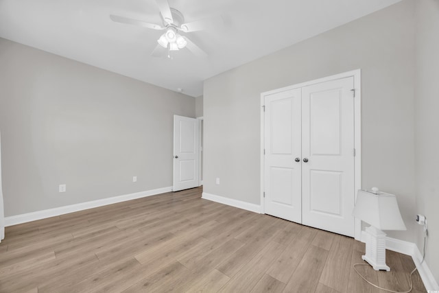 unfurnished bedroom with ceiling fan, light hardwood / wood-style floors, and a closet