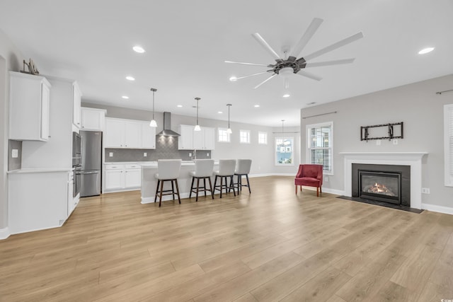 living room with ceiling fan and light wood-type flooring