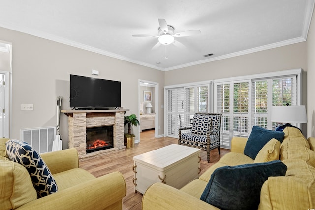 living room featuring ceiling fan, light hardwood / wood-style flooring, ornamental molding, and a healthy amount of sunlight