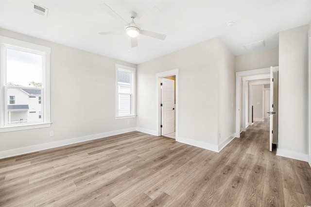 empty room with ceiling fan and light hardwood / wood-style flooring