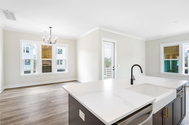 kitchen with a center island with sink, light stone counters, decorative light fixtures, crown molding, and stainless steel dishwasher