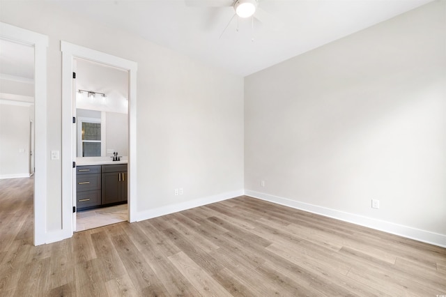 unfurnished room featuring sink, ceiling fan, and light hardwood / wood-style flooring