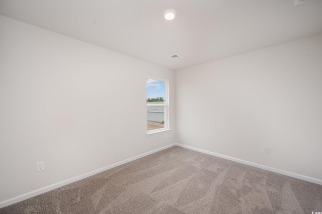 carpeted empty room featuring baseboards