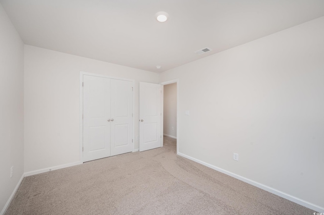 unfurnished bedroom featuring carpet flooring, baseboards, visible vents, and a closet