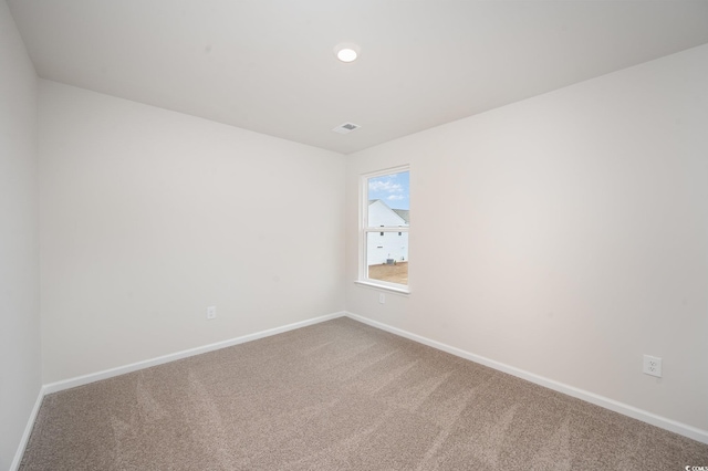 spare room featuring baseboards, carpet flooring, and visible vents