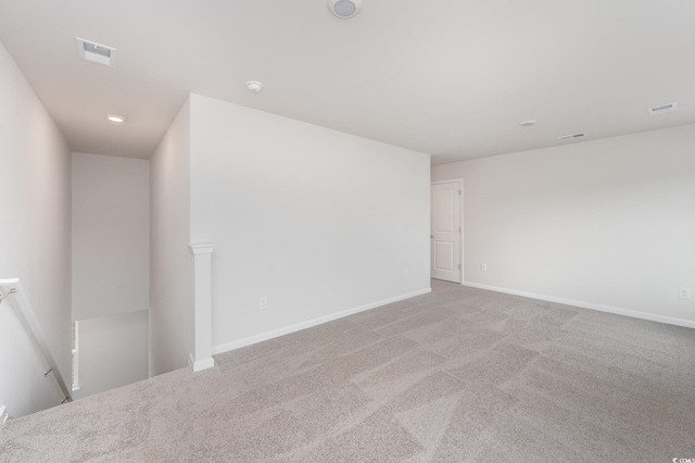 empty room featuring carpet floors, baseboards, and visible vents