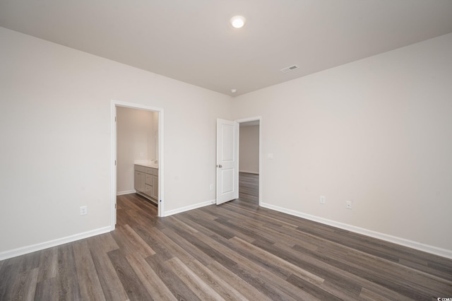 unfurnished bedroom with baseboards, visible vents, and dark wood-style floors