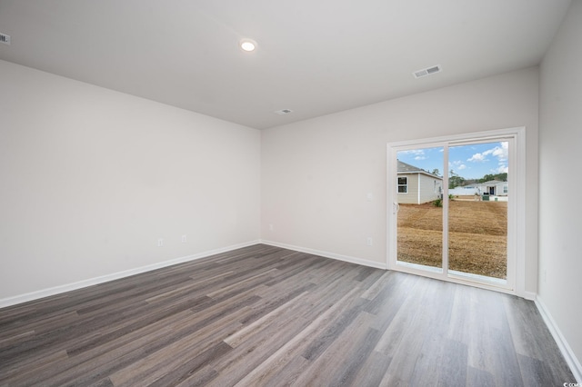 empty room with baseboards, recessed lighting, dark wood finished floors, and visible vents