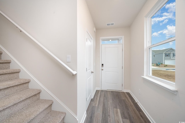 entryway with baseboards, dark wood-type flooring, stairs, and visible vents