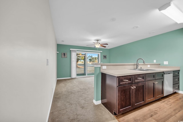 kitchen featuring light countertops, a sink, dark brown cabinetry, dishwasher, and baseboards