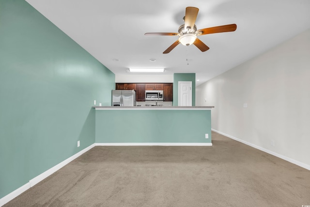 unfurnished living room with carpet floors and baseboards