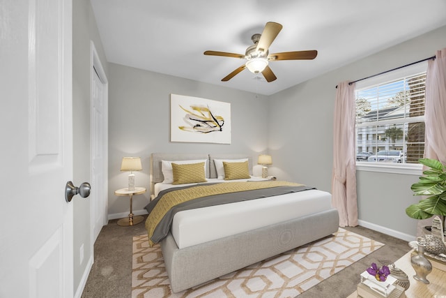 carpeted bedroom with ceiling fan, a closet, and baseboards