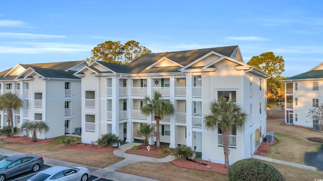 view of property with uncovered parking and central AC