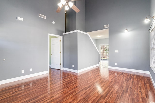 spare room featuring wood-type flooring, ceiling fan, and a high ceiling