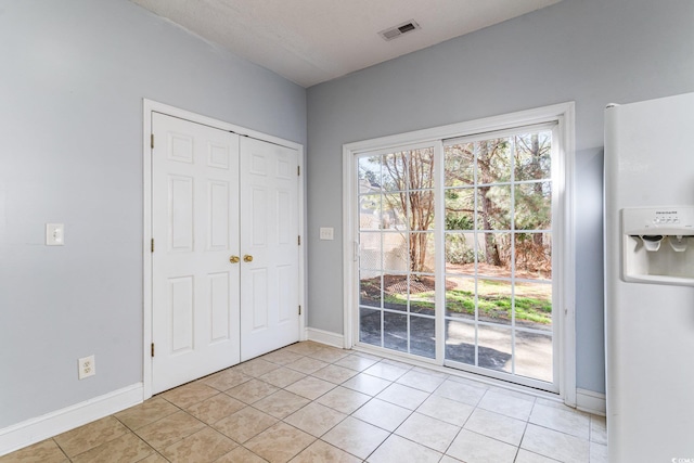 doorway to outside with plenty of natural light and light tile patterned floors