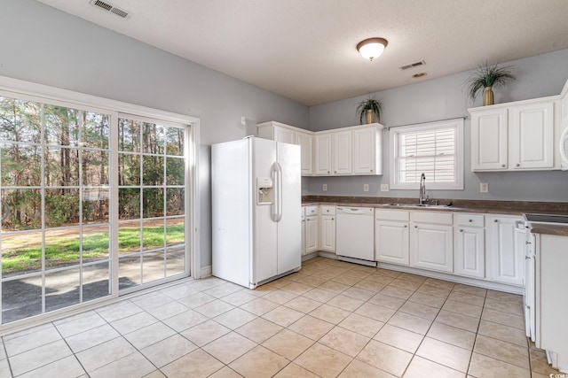 kitchen with white appliances, sink, and white cabinets