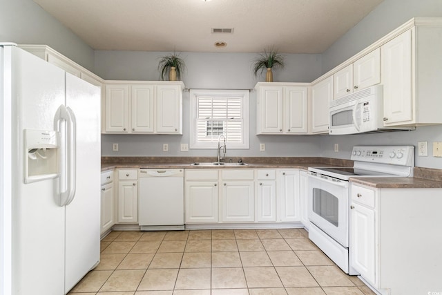 kitchen with sink, white appliances, white cabinets, and light tile patterned flooring