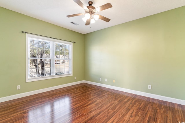 spare room featuring dark hardwood / wood-style flooring and ceiling fan