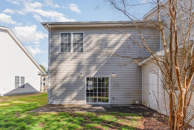 back of house with a lawn and a patio