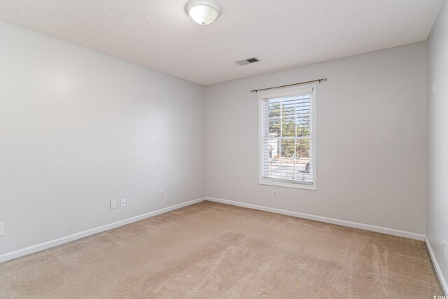 carpeted empty room with a textured ceiling