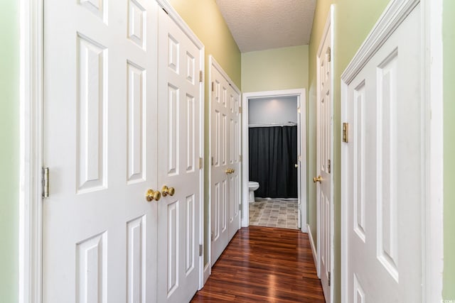 hall featuring dark hardwood / wood-style floors and a textured ceiling