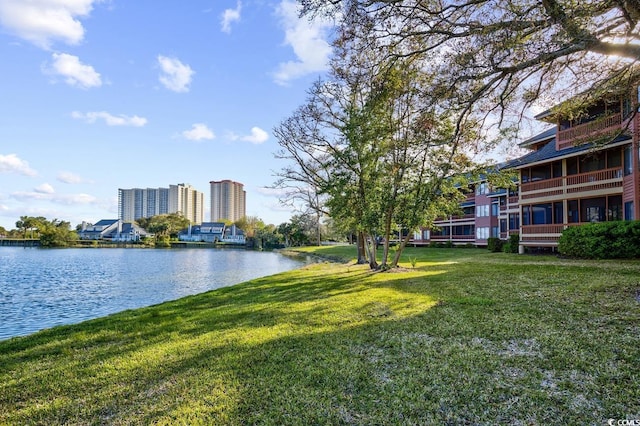 view of property's community with a yard and a water view