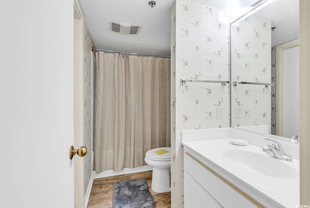 bathroom featuring wood-type flooring, curtained shower, vanity, and toilet