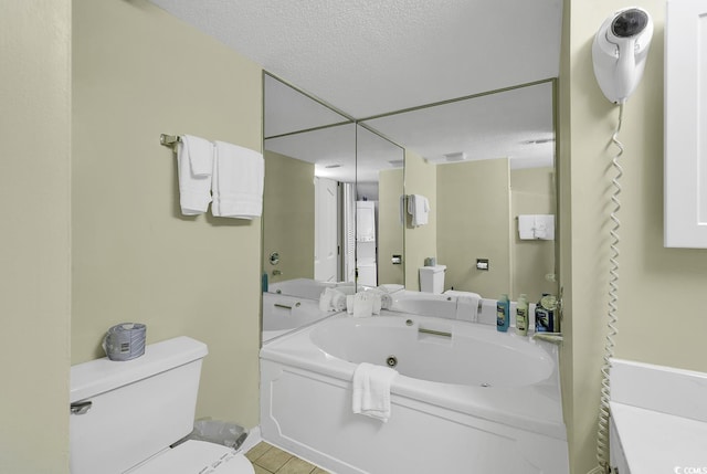 bathroom featuring a bathtub, toilet, and a textured ceiling