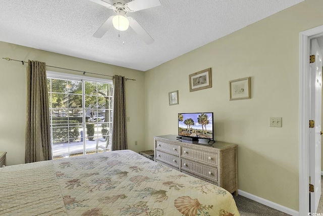 carpeted bedroom with ceiling fan and a textured ceiling