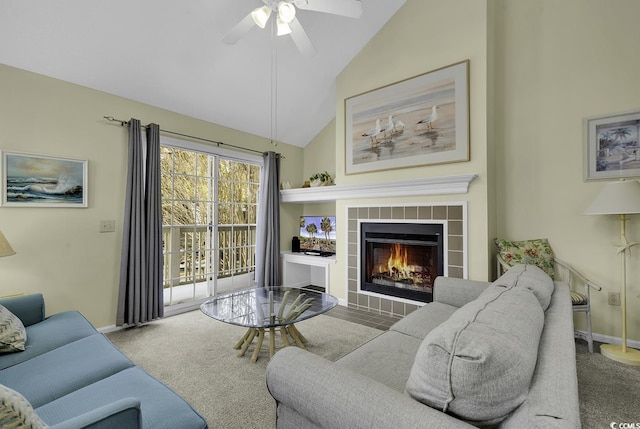 living room featuring a tiled fireplace, high vaulted ceiling, ceiling fan, and carpet