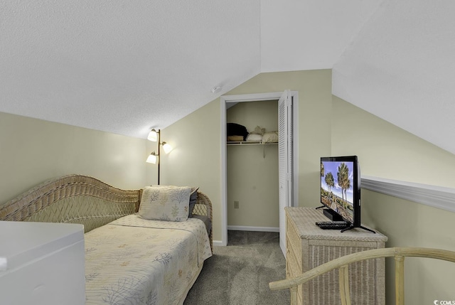 bedroom with vaulted ceiling, carpet flooring, a textured ceiling, and a closet