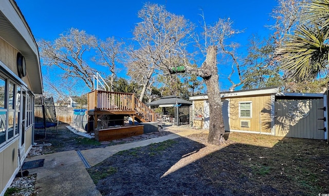 view of yard with a trampoline and a storage unit