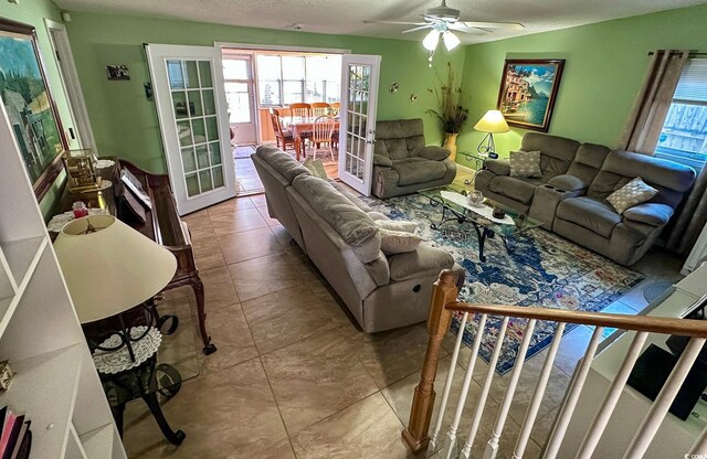 living room featuring a textured ceiling, french doors, ceiling fan, and light tile patterned flooring