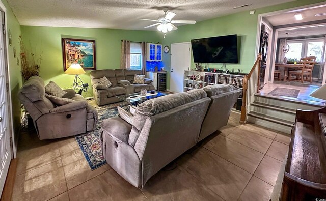 living room with ceiling fan and a textured ceiling