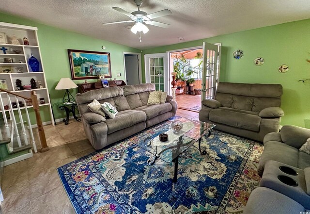 tiled living room with ceiling fan, vaulted ceiling, and a textured ceiling