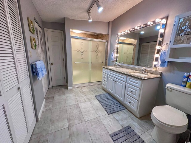 bathroom featuring hardwood / wood-style floors, an enclosed shower, vanity, a textured ceiling, and toilet