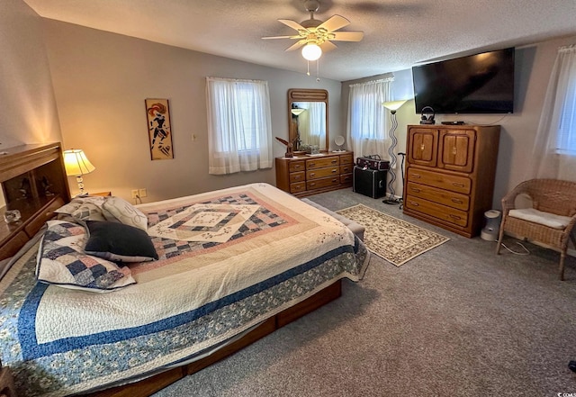 carpeted bedroom with ceiling fan, vaulted ceiling, and a textured ceiling