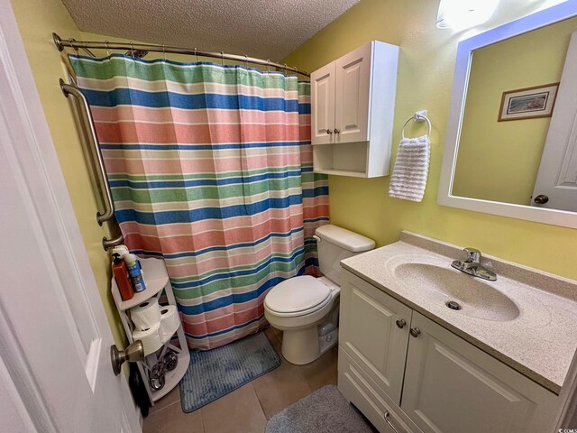 bathroom with vanity, a textured ceiling, curtained shower, tile patterned floors, and toilet