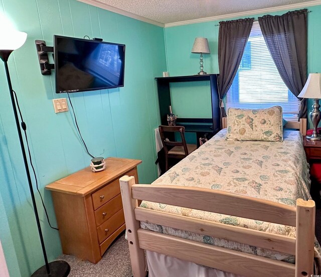 carpeted bedroom featuring ornamental molding and a textured ceiling