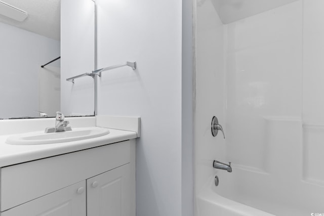 bathroom with vanity, shower / bathing tub combination, and a textured ceiling