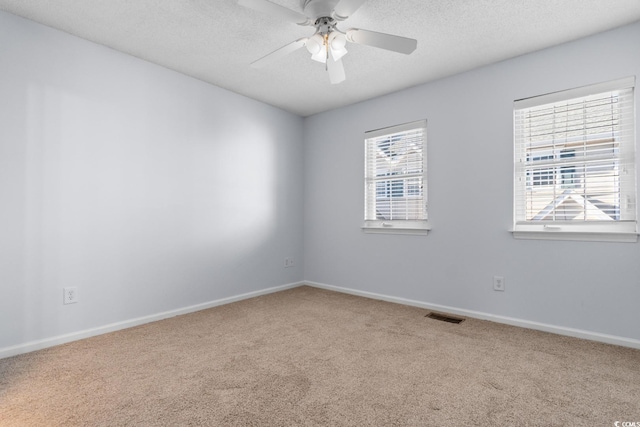 spare room with ceiling fan, carpet flooring, and a textured ceiling