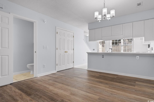 interior space with hardwood / wood-style floors, a textured ceiling, and a chandelier