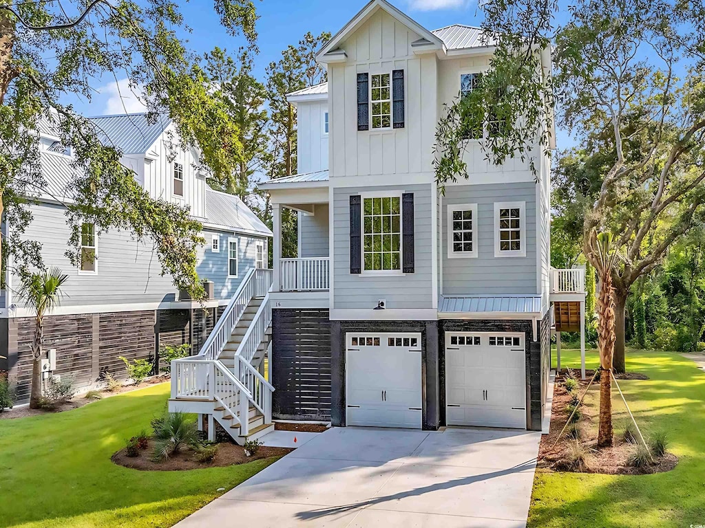 view of front of house featuring a garage, a front yard, and covered porch